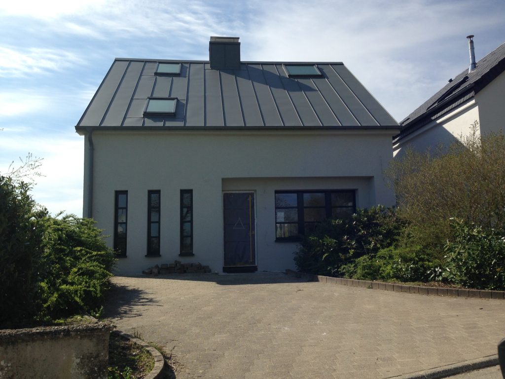 Außenansicht eines modern saniertes Einfamilienhaus mit einer großzügigen Einfahrt.