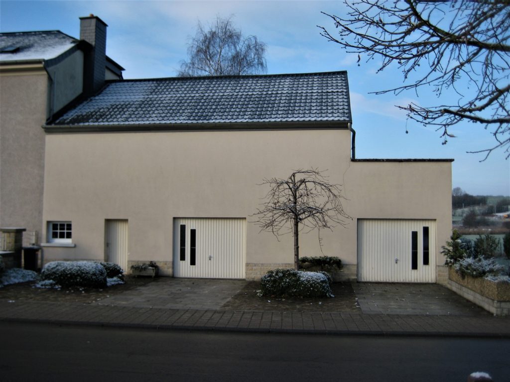 Braun verputzte Bauernscheuen, mit Schnee bedeckt.